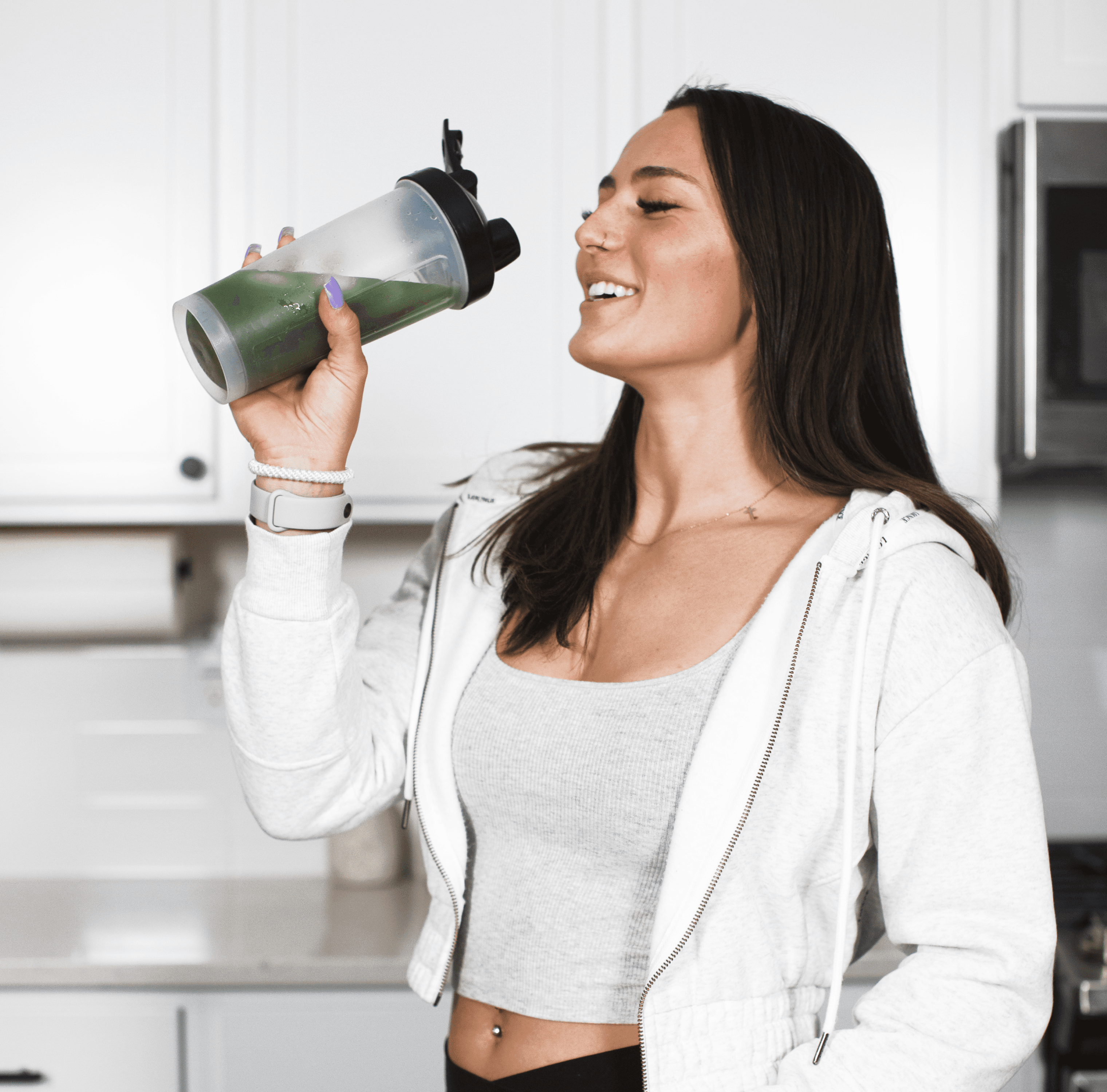 woman drinks liquid greens bottle